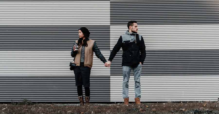 man and woman holding hands while looking away