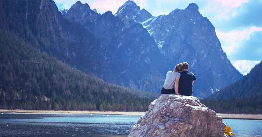 A couple in front of a lake.